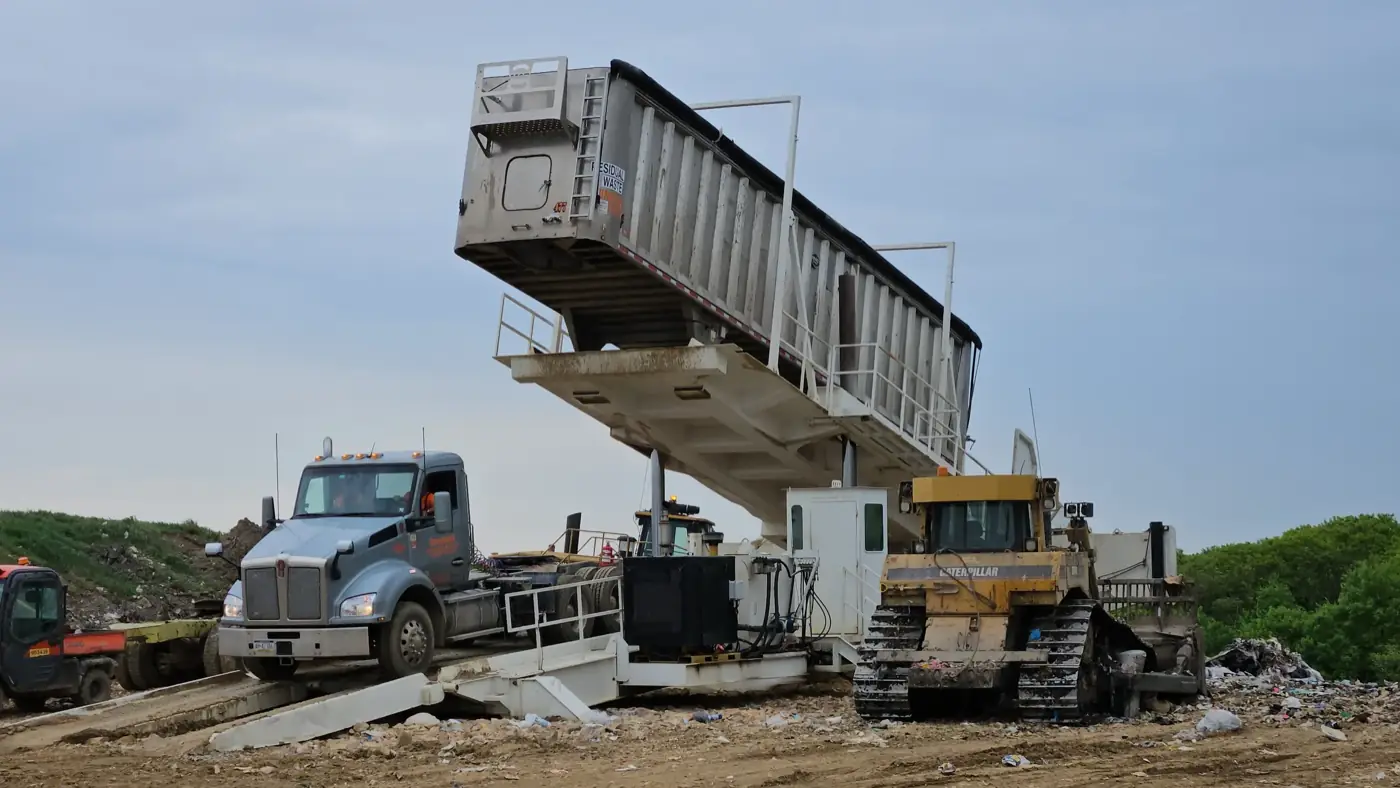 Kenworth and transfer trailer raised on a landfill platform tipper